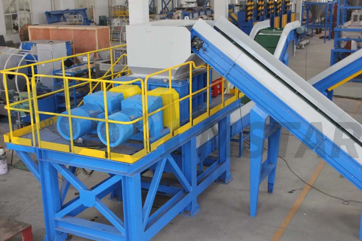 Double-shaft shredder on a raised platform with dual motors and infeed belt conveyor