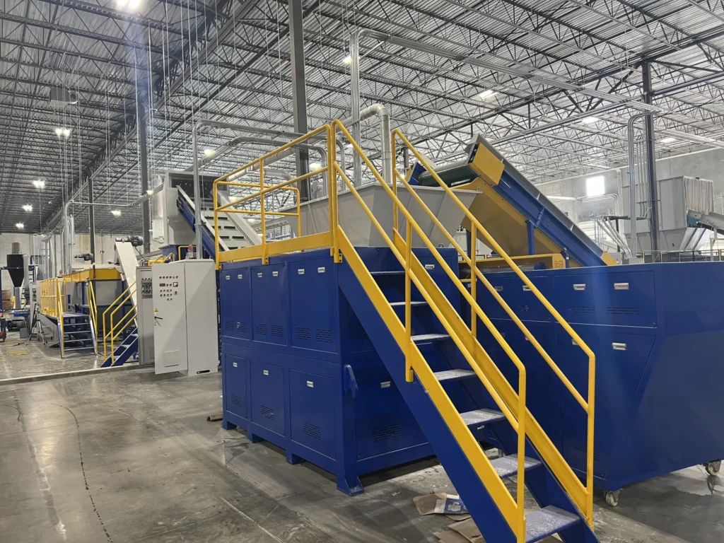 Shredding section of a PE film washing line – shredder unit with access stairs and infeed conveyor