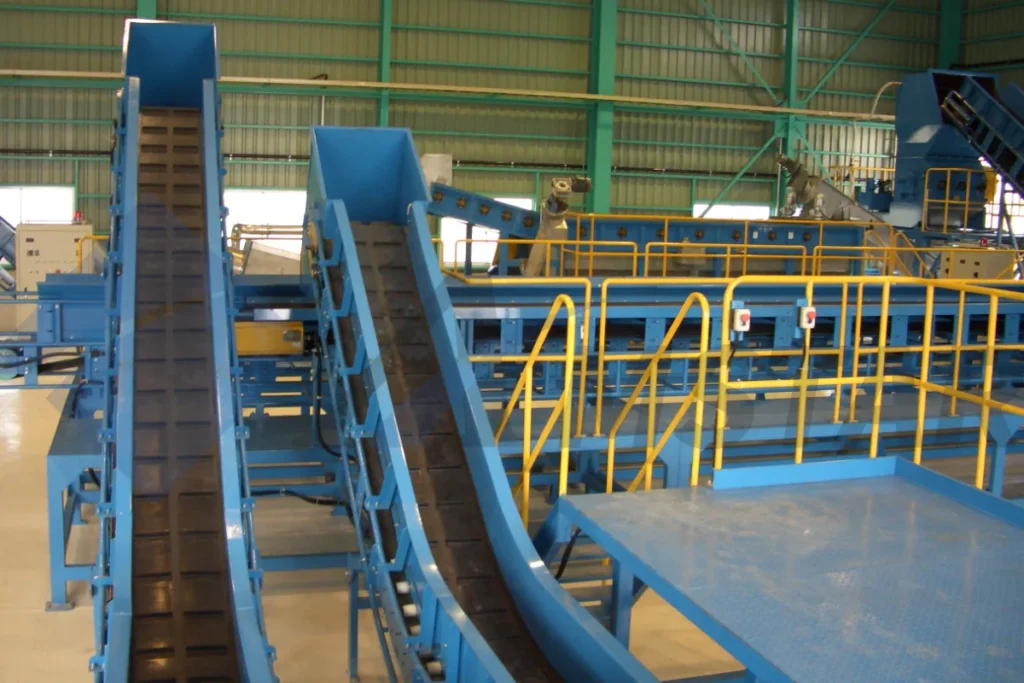 Chain conveyors feeding a PE film washing line, beside railed walkways