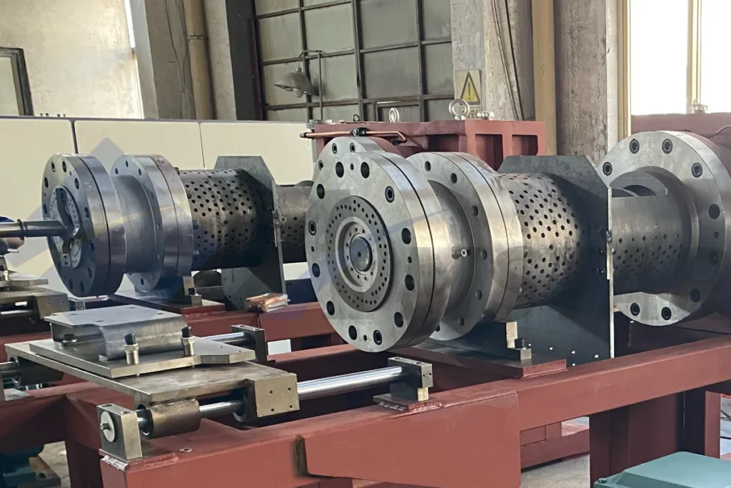 Perforated barrel sections of the screw press squeezer, where the water drains out