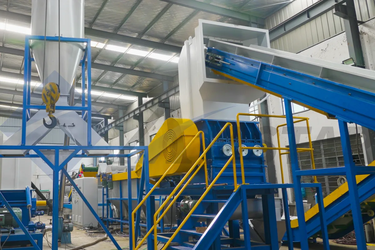 Wet plastic granulator with yellow pulley guard in a PE film washing line