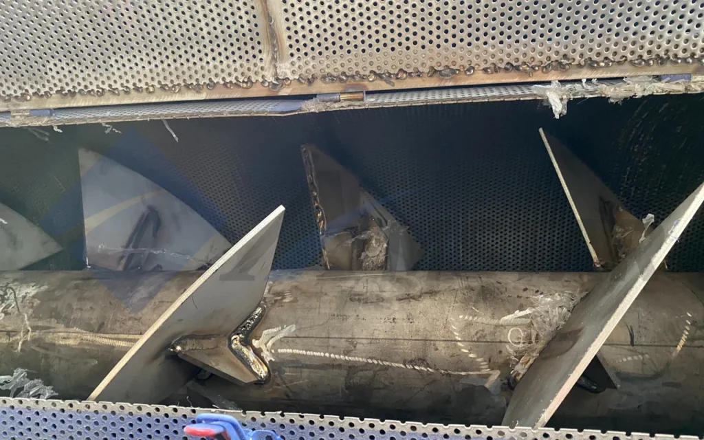 Inside a friction screw washer: inclined paddles on the rotor within the perforated screen